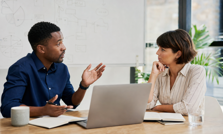 Zwei Personen diskutieren aufmerksam eine neue Idee in einem modernen Arbeitsumfeld [Bildinhalt mit KI erstellt]